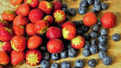 Strawberries and blueberries on a wooden surface